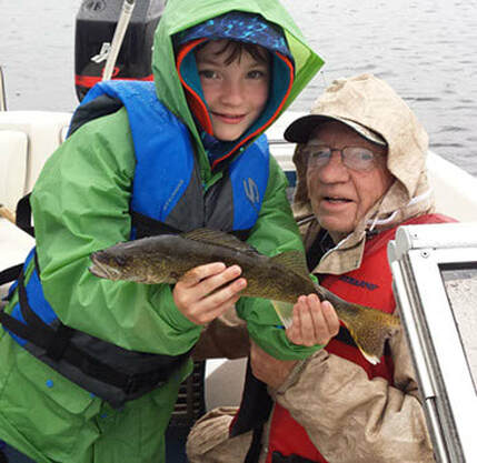 child and grandfather with small walleye
