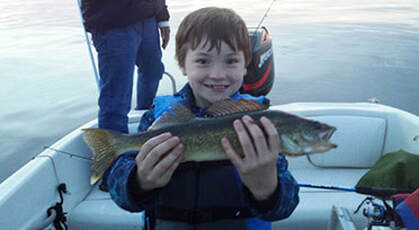 Child holding a freshly caught walleye